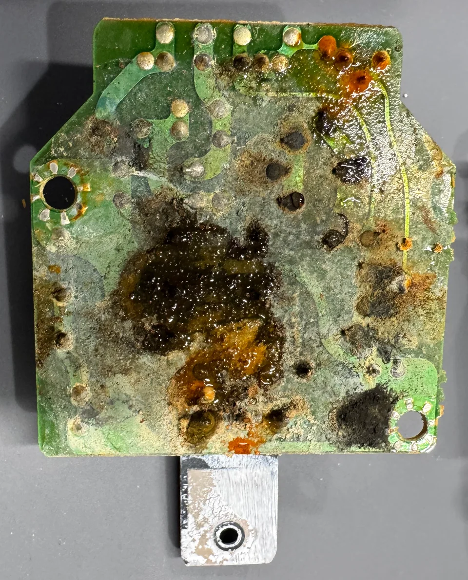 The humidifier circuit board with water damage and corrosion before cleaning.
