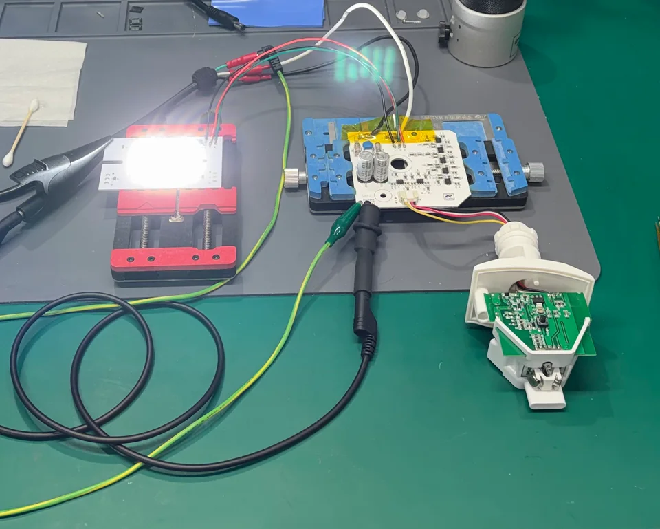 The outdoor smart light's LED array illuminated on the electronics workbench.